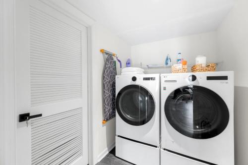a washer and dryer in a white laundry room at Outdoor Projector, Arcade, Fire Pit, 2 Car Garage, 2 Living Rooms in Snellville