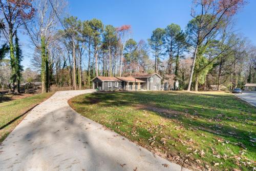 a driveway leading to a house in the woods at Outdoor Projector, Arcade, Fire Pit, 2 Car Garage, 2 Living Rooms in Snellville