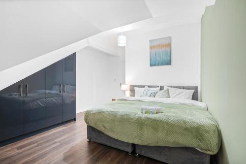 Leicester Luxury Apartments - Church Gate في ليستر: غرفة نوم بيضاء بسرير ودرج