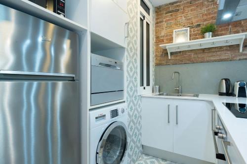 een keuken met een wasmachine en een roestvrijstalen koelkast bij Bright and cozy flat in the heart of the city in Barcelona