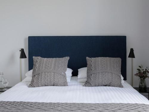 a large bed with a blue headboard and pillows at Pembroke Hall in Dublin