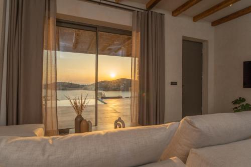 a living room with a couch and a large window at Villa Mirabilis in Ios Chora