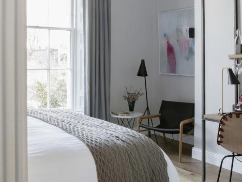 um quarto com uma cama, uma cadeira e uma janela em Pembroke Hall em Dublin