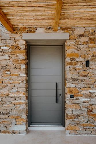 a gray garage door in a brick wall at Villa Mirabilis in Ios Chora