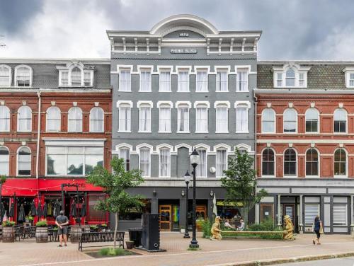 a large building with people walking in front of it at The Phenix Historic DTWN Hotel, Room # 310 in Bangor