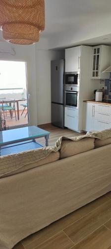 a living room with a couch and a kitchen at ATICOS Primera Linea en ZAHARA DE LOS ATUNES in Zahara de los Atunes