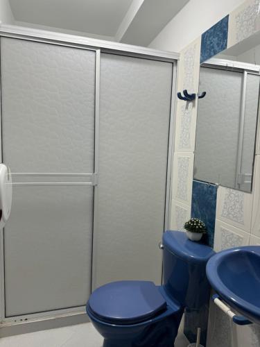 een badkamer met een blauw toilet en een spiegel bij Apartamento amoblado para familia y amigos in San Vicente de Chucurí