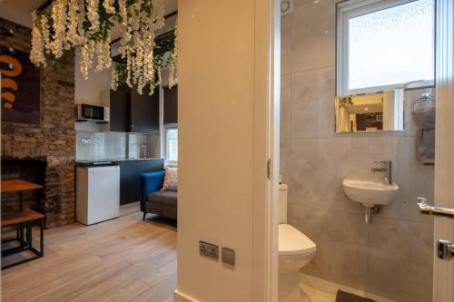 a bathroom with a toilet and a sink in a room at Cosy 1 Bed Duplex - Close to Metro - NW2 in London
