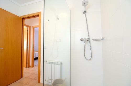 La salle de bains est pourvue d'une douche avec une porte en verre. dans l'établissement Casa Cossis, à L'Escala