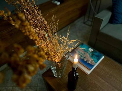 a candle and a glass vase on a table at Thalia Apartments in Agia Galini