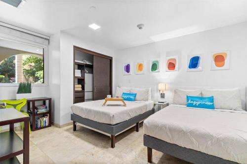 a bedroom with two beds and a table in it at Beautiful Vibes Sun Kiss Serenity your Stylish Apt Just Steps from Eagle Beach in Palm-Eagle Beach
