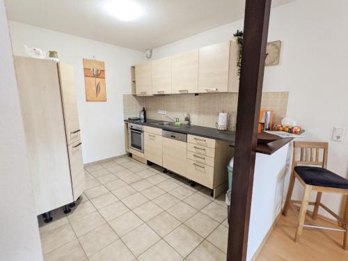 a kitchen with a refrigerator and a tiled floor at W5 - Urlaubsmagie - Wohnung mit Grill, Terrasse & Pool in Lichtenhain