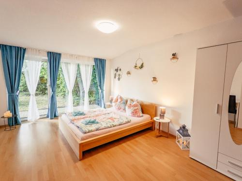 1 dormitorio con cama y ventana grande en Urlaubsmagie - Wohnung mit Grill, Terrasse & Pool -W5, en Lichtenhain