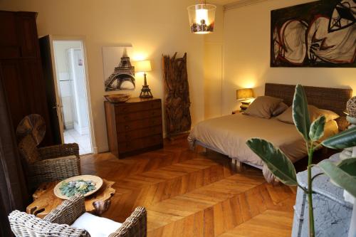 1 dormitorio con 1 cama y suelo de madera en A Room In Paris en París