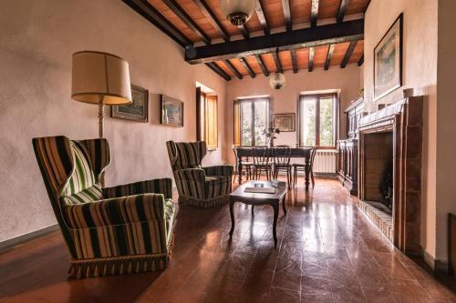 a living room with chairs and a table and a fireplace at CasaLeTolfe Residence in Siena