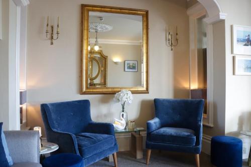 a waiting room with blue chairs and a mirror at The New England in Eastbourne