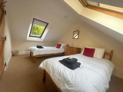 3 Bed Cottage in the Peaceful Village Wanlockhead في Wanlockhead: غرفة نوم علوية بسريرين ونافذة