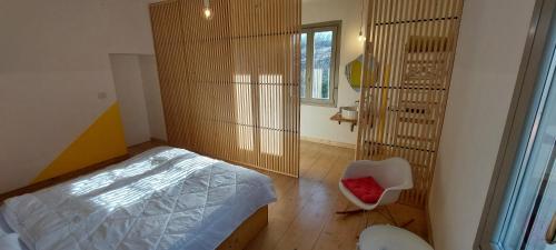 a bedroom with a bed and a chair and a window at lassù minihotel 