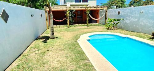 a swimming pool in a yard next to a house at Casa piscina Atlantida in Atlántida