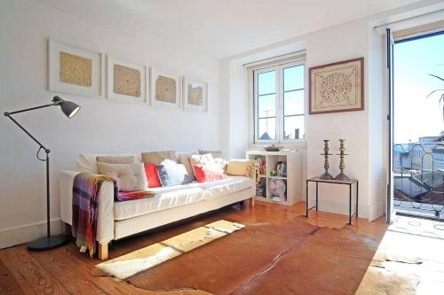ein Wohnzimmer mit einem Sofa und einem Fenster in der Unterkunft DPJ Romantic JARDIM apt - LIFT! - PR.REAL/BAIRRO ALTO! in Lissabon