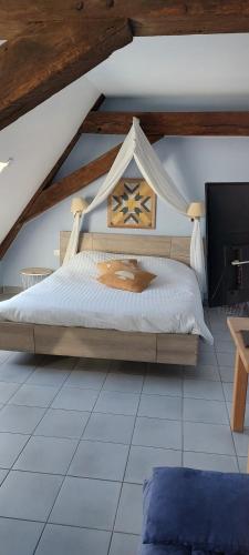 a bedroom with a large bed in a attic at La Forge De Labbaye in Liessies