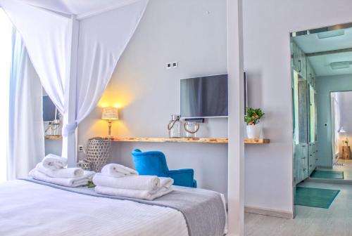una camera da letto con asciugamani su un letto e una sedia blu di Four Seasons Villa Chania a Fournés