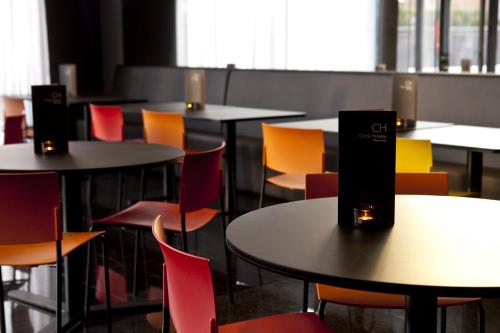 a group of tables and chairs in a room at Hotel Carris Marineda in A Coruña