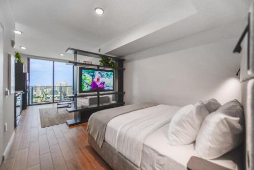 - une chambre avec un lit et une télévision à écran plat dans l'établissement Panoramic Views of City and Bay from this Studio, à Miami