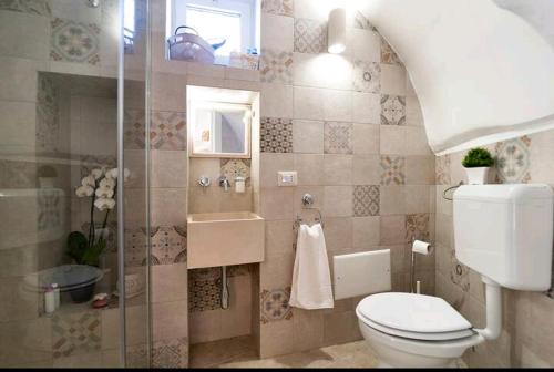 La petite salle de bains est pourvue de toilettes et d'un lavabo. dans l'établissement Kamares, à Nardò