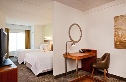 Habitación de hotel con cama y espejo en SpringHill Suites Chesapeake Greenbrier, en Chesapeake