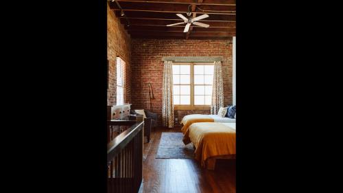 a bedroom with two beds and a brick wall at The Icon in Springfield