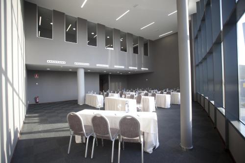 a banquet hall with white tables and chairs at Hotel Carris Marineda in A Coruña