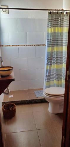 a bathroom with a toilet and a shower curtain at Casa piscina Atlantida in Atlántida