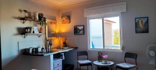 a bathroom with a sink and a window and chairs at Bed & Breakfast Casa Ceratonia in Alora