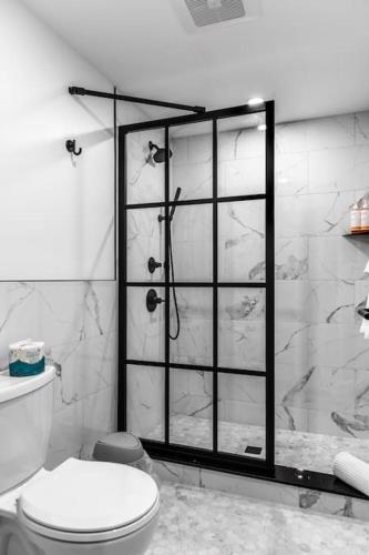 a bathroom with a shower with a toilet and a glass door at The Phenix Historic DTWN Hotel, King Bed, Room # 311 in Bangor