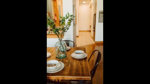 a wooden table with plates and a vase with flowers at The Icon in Springfield