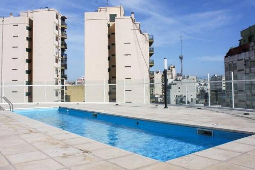 a swimming pool on the roof of a building with tall buildings at BOLI 0613 San Telmo Charm: Monoambiente Cozy in Buenos Aires