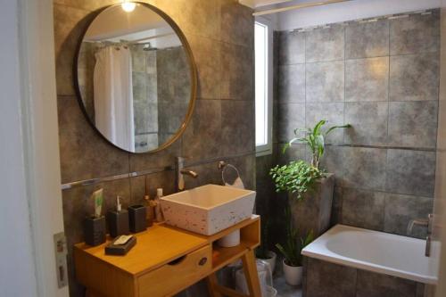y baño con lavabo, espejo y bañera. en Nómade Habitación en Rufino