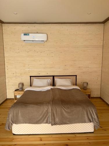 a bedroom with a large bed with a wall at MaRu House in Dilijan