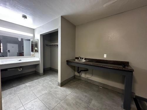 an empty bathroom with a sink and a mirror at Sunpark Inn & Suites in San Bernardino