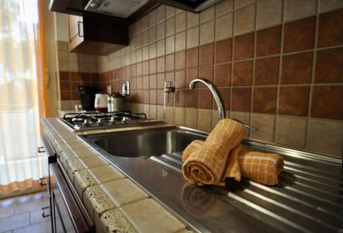 eine Spüle mit einem Wasserhahn und 2 Handtüchern in der Unterkunft Le 3 Elle Vaticano San Pietro in Rom