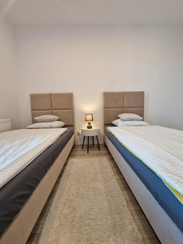 2 Betten nebeneinander in einem Zimmer in der Unterkunft Szklane Tarasy Premium Two Bedrooms FAKTURA FAST CHECK-IN in Rzeszów