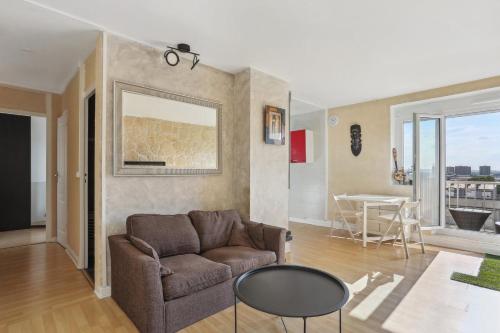 a living room with a couch and a table at Le Calme à deux pas de Paris in Nanterre