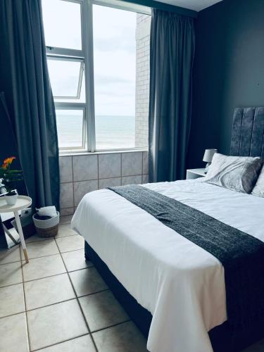 a bedroom with a large bed and a window at Beach View in Scottburgh