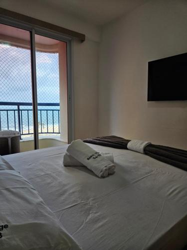a bedroom with a bed with a view of the ocean at Apartamento Beach Village Praia do Futuro by WL Temporada in Fortaleza