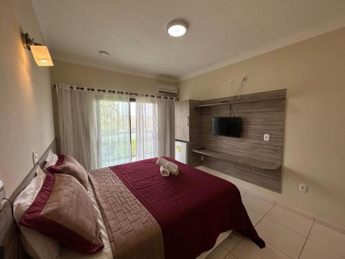 a bedroom with a bed with a teddy bear on it at Hotel Aconchego do Velho Chico in Piranhas