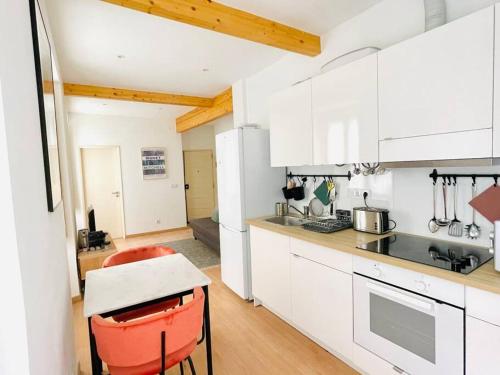 uma cozinha com armários brancos e uma cadeira vermelha em RSRC Central & Bright 1BR apartment em Lisboa