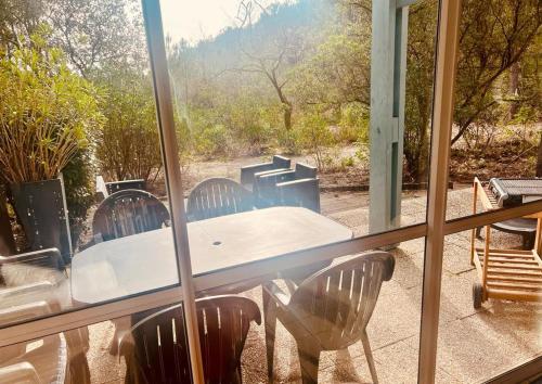 - une table et des chaises sur une terrasse couverte avec une fenêtre dans l'établissement maison lacanau ocean, à Lacanau