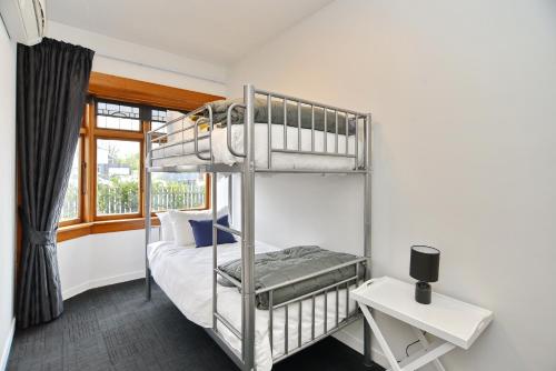 a bedroom with a bunk bed and a window at Grand Heritage 5 BRMs CBD villa with carparks in Christchurch