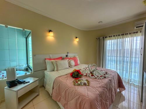 a bedroom with a bed with pink sheets and a mirror at Hotel Aconchego do Velho Chico in Piranhas